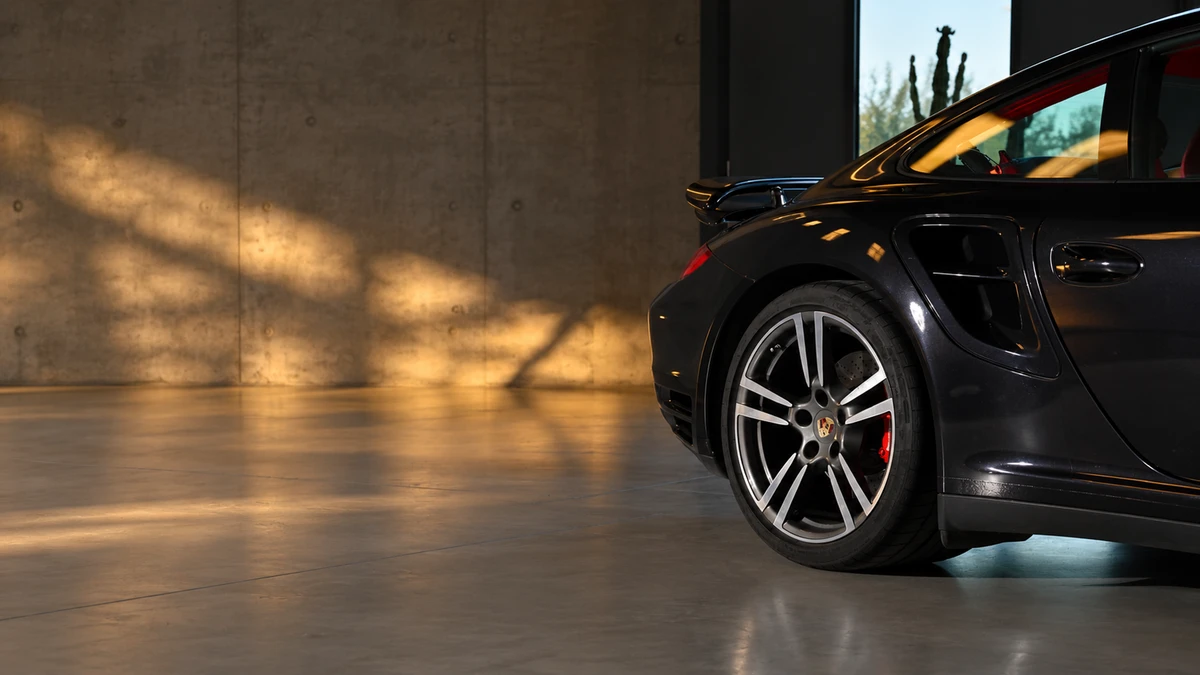 Czarne Porsche w ciepłym świetle we wnętrzu showroomu