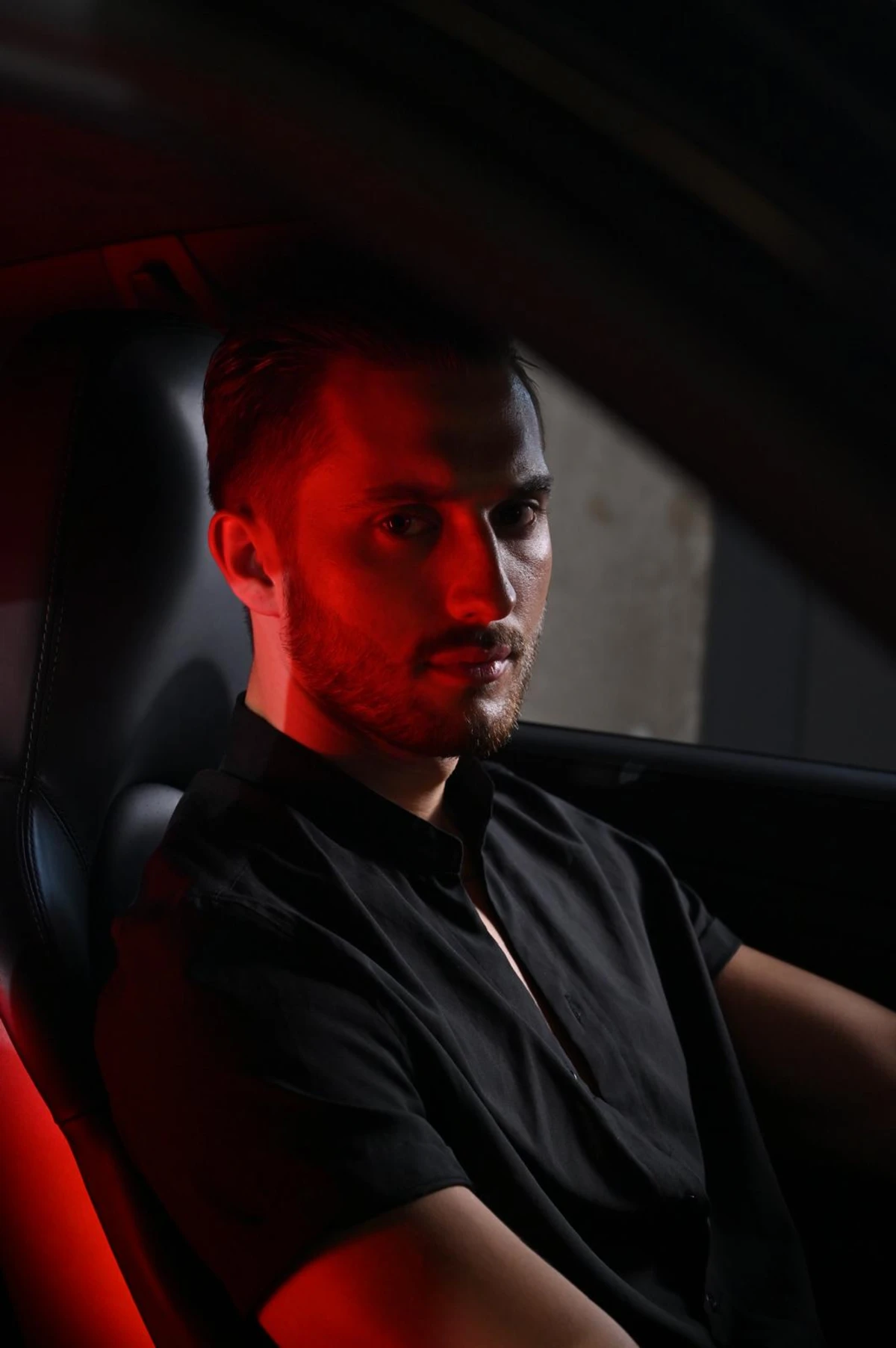 Portret mężczyzny we wnętrzu samochodu z czerwonym światłem